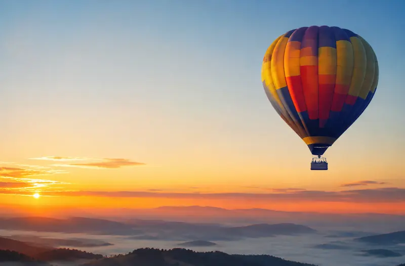 A hot air balloon floating above the landscape, representing the symbolic meaning of dreams about freedom, growth, and seeing life from a higher perspective.